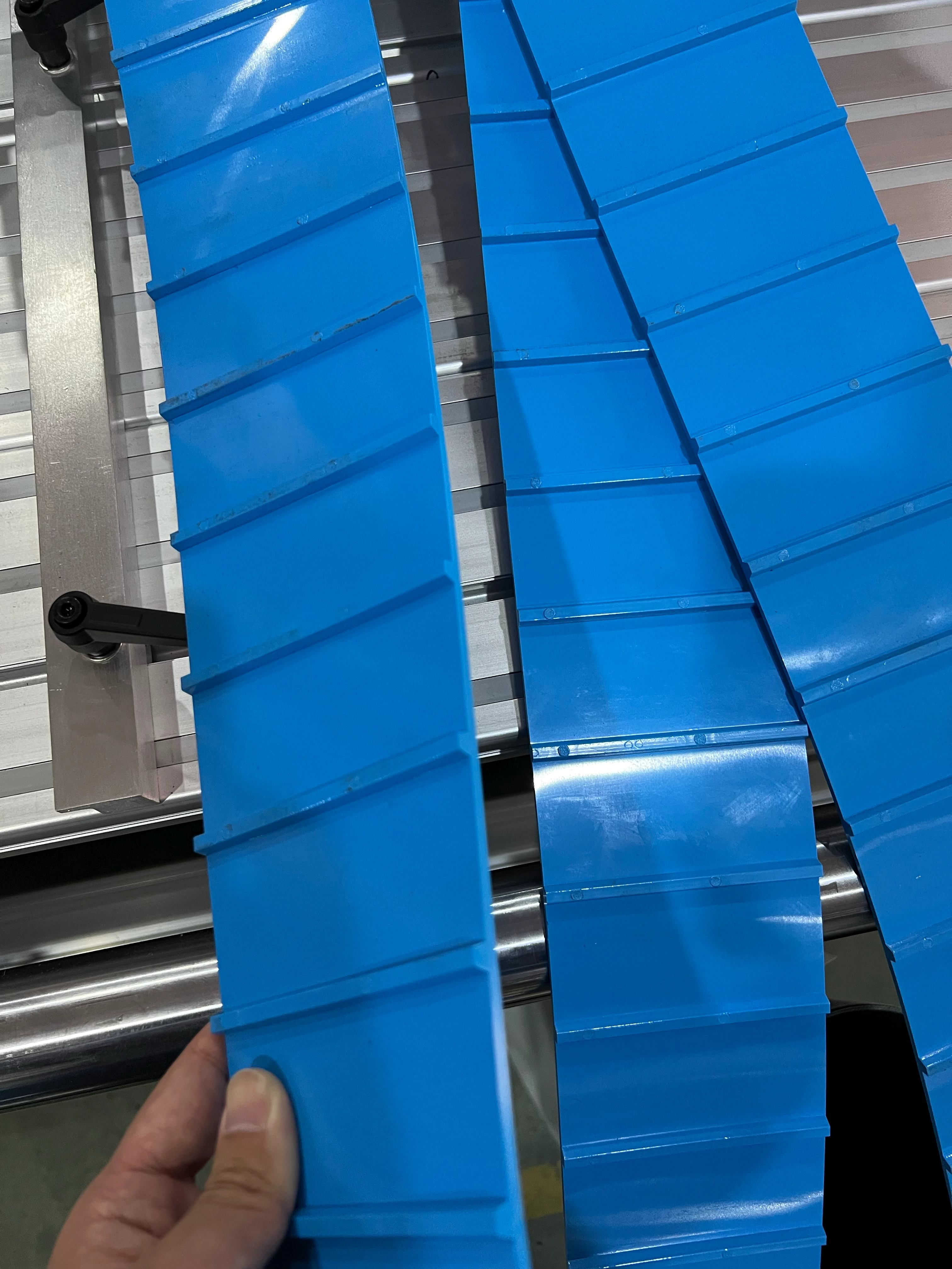 Beltwin slitter making a vertical cut on a green PVC conveyor belt